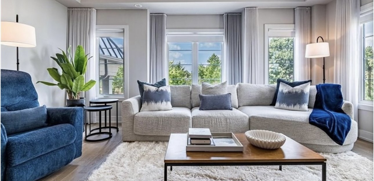 The townhouse sitting room with a sectional sofa, navy accents and a white shag rug