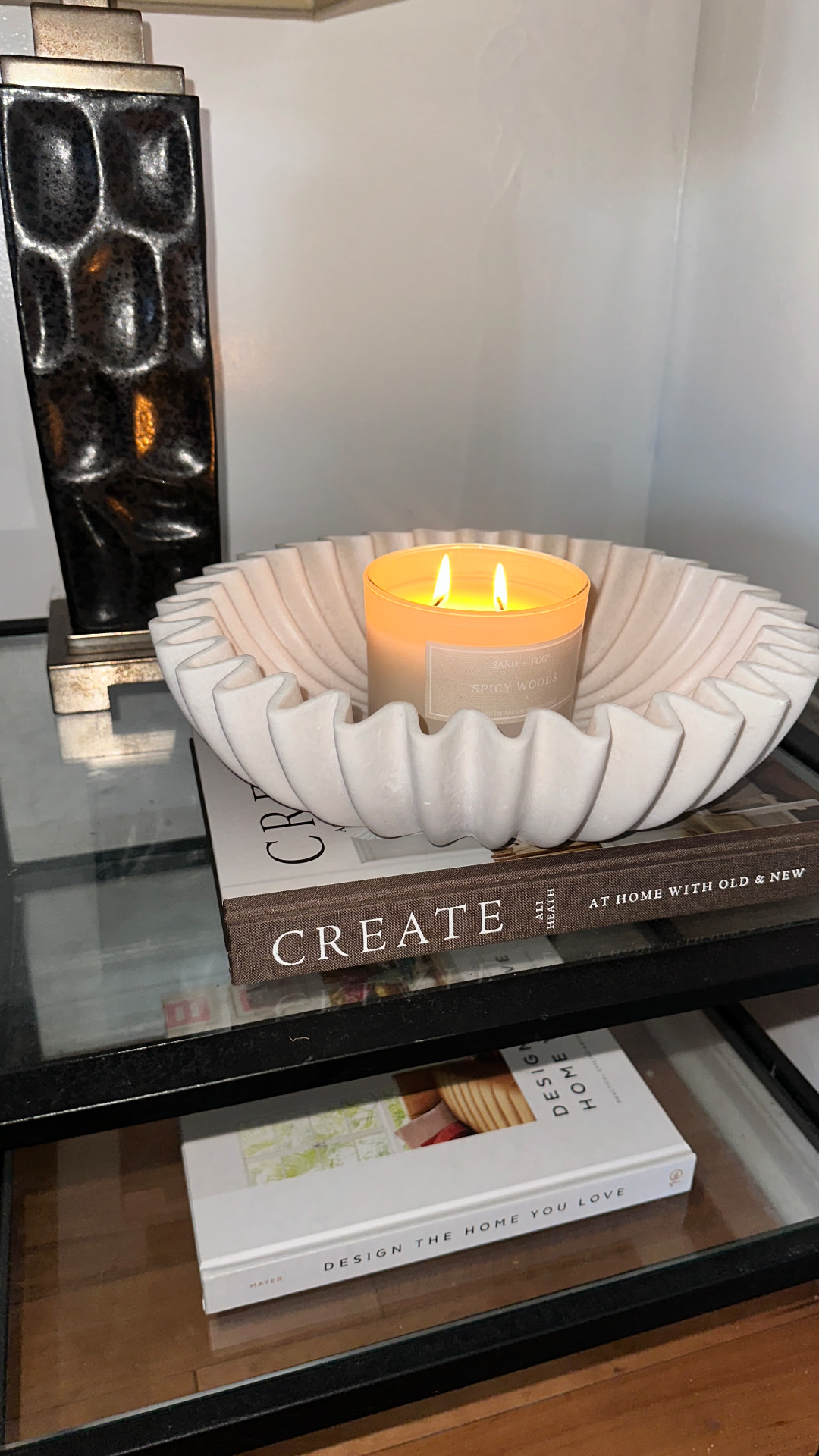 A lit candle in a sculptural white bowl styled on a console — an example of Natalya's décor styling